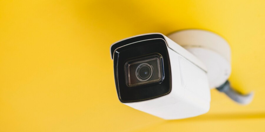 A modern security camera installed on a ceiling.